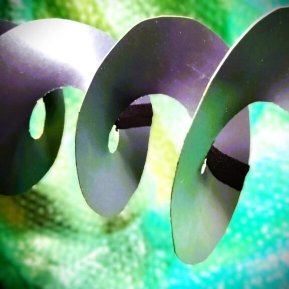 Home spiral time impression, hanging in front of a green-blue background